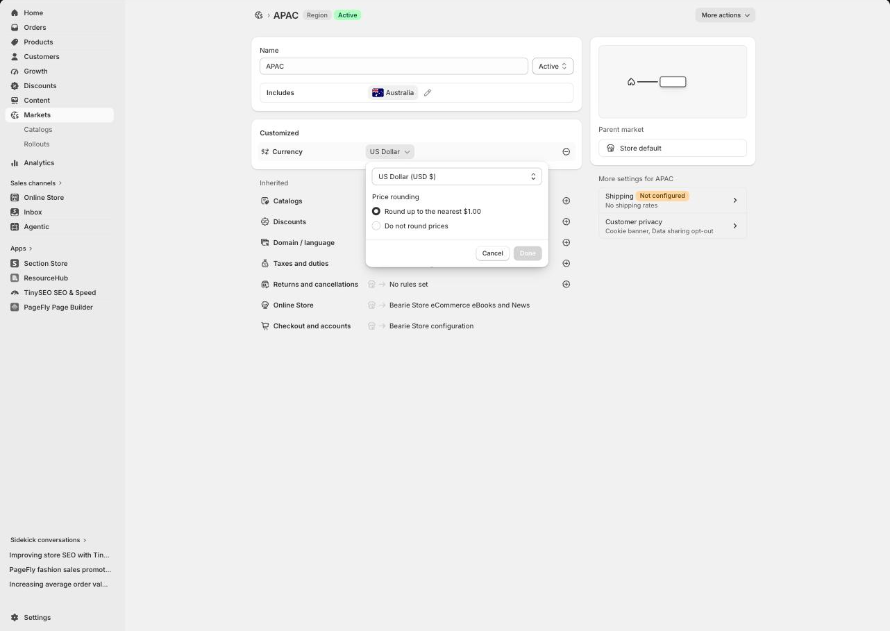 Currency customization panel open inside a Shopify market, showing the currency selector and the Price rounding choice between rounding up to the nearest whole unit and not rounding